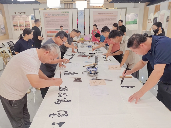 西林县文联书法家协会会员现场创作书法作品。黄燕群摄